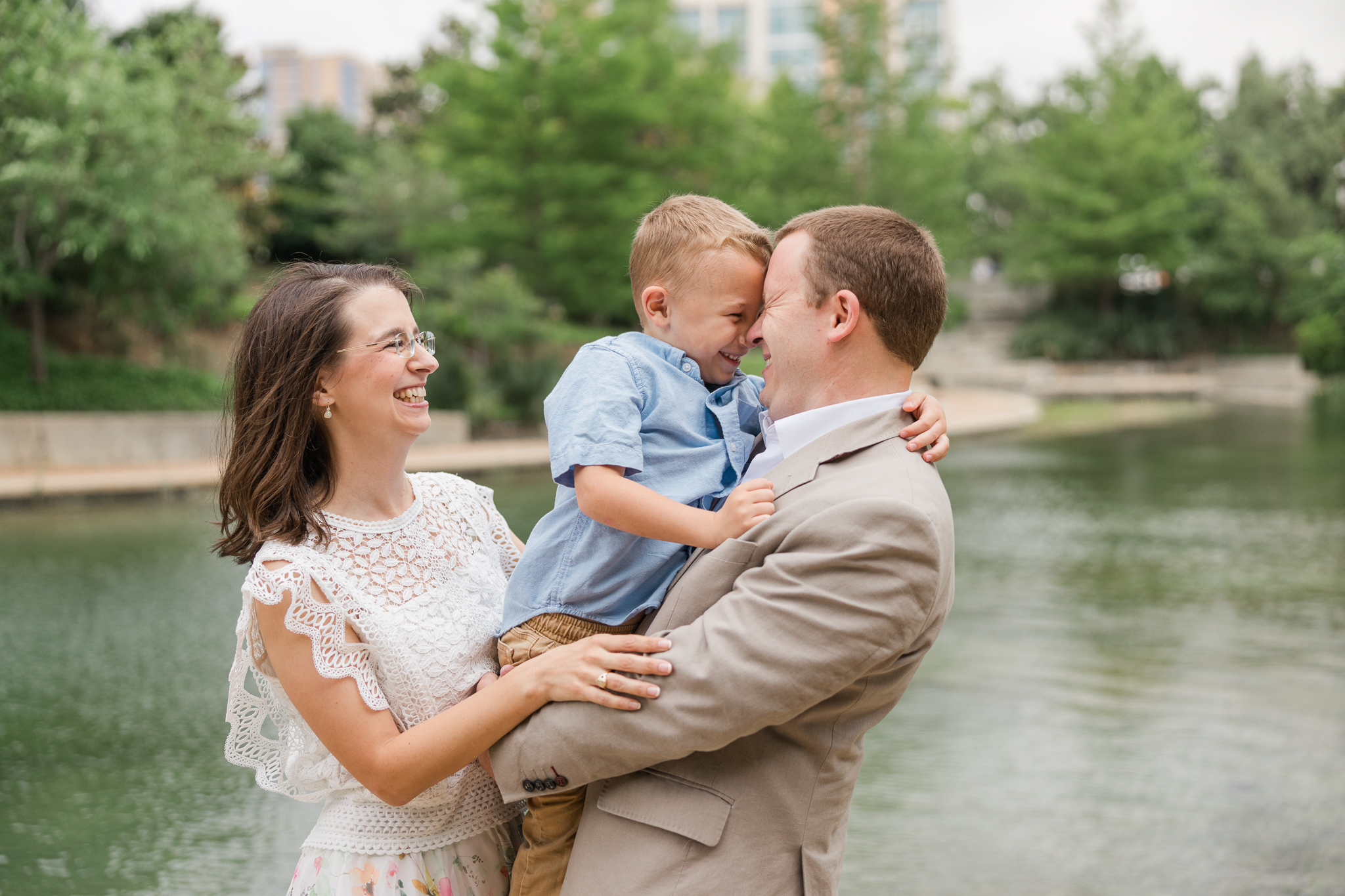 couple with young son snuggling in front of lake