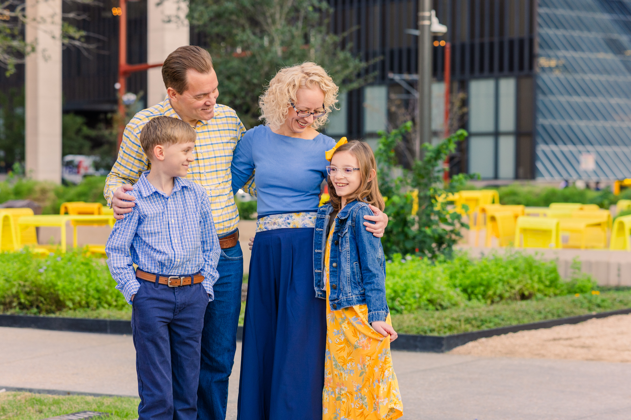 young family of four in downtown Houston theater district, dressed in shades of yellow and blue