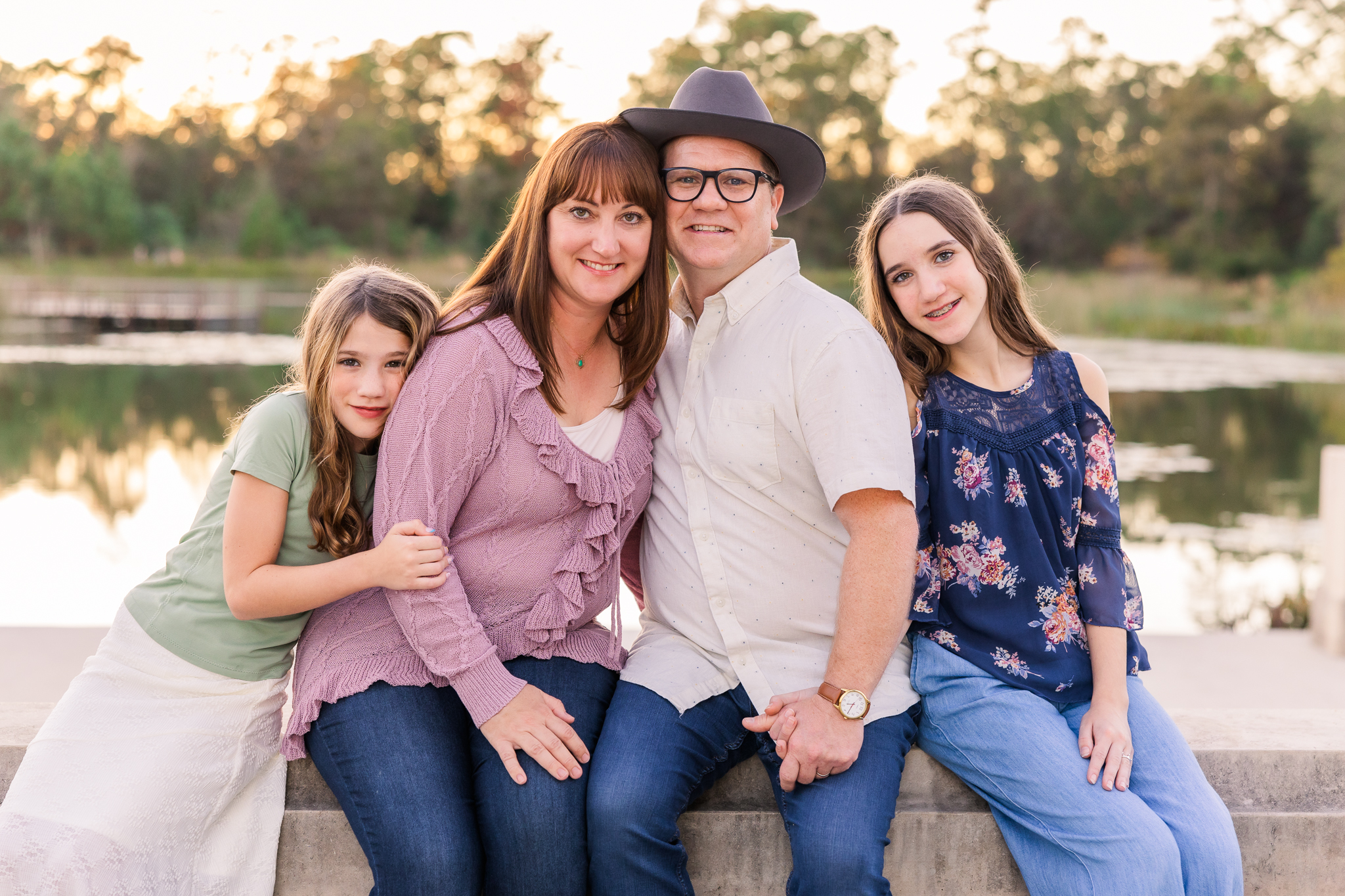 couple with teen and preteen girls in jeans and soft colors at sunset