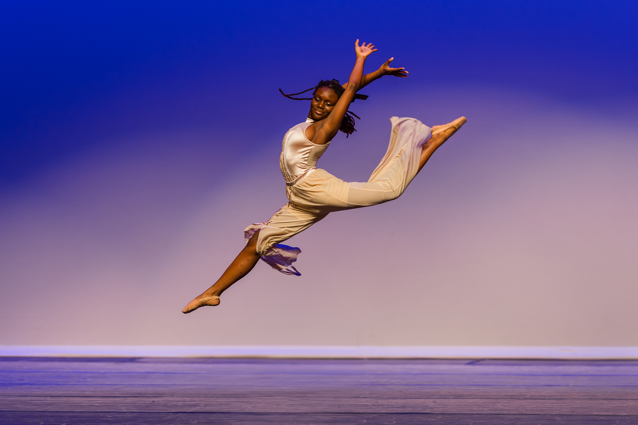 middle school dancer performs fire bird leap on stage